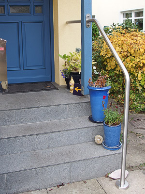 Edelstahlrohr gebogen - Enden mit Edelstahlronde und Edelstahlplatte verschweißt - zur Montage als freistehender Handlauf an einer Eingangstreppe außen