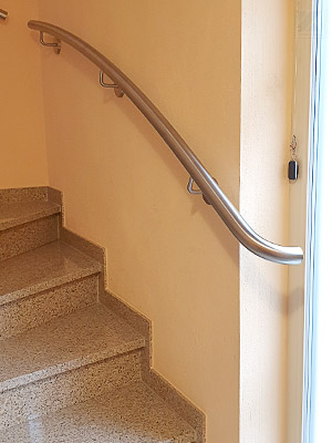 Edelstahlhandlauf gewalzt am unteren Treppenlauf der 2x viertelgewendelten Treppe - auf Kundenwunsch Handlaufanfang mit 90°-Bogen zur Wand/Fenster, zum besseren Greifen am Treppenbeginn