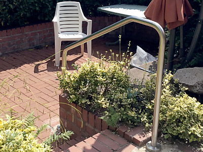 Edelstahl Handlauf freistehend gebogen in der Form 5 - Handlauf an der Gartentreppe von der Terrasse zum Sitzplatz im Garten montiert