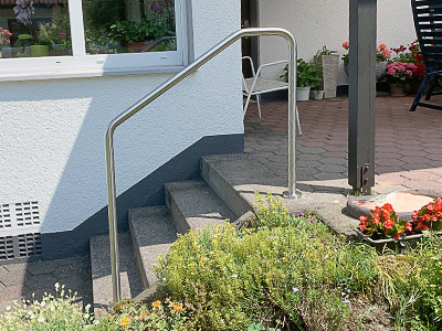 Edelstahl Handlauf freistehend gebogen in der Form 5 - aufgesetzte Montage an Terrassentreppe