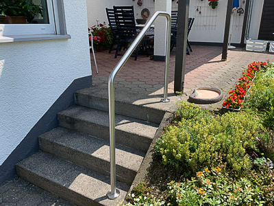 Edelstahl Handlauf freistehend gebogen in der Form 5 - aufgesetzte Montage an Terrassentreppe, Ansicht von vorn