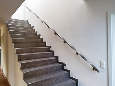 Edelstahl Handlauf gerade für Innentreppe an einer Wand aus Hochlochziegeln montiert