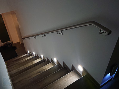 Edelstahl Treppenhandlauf gebogen für lange Innentreppe mit beleuchteten Stufen